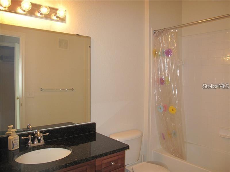 3593 Conroy Road, Unit 421 Orlando, FL 32839 - Photo 13 of 28 a bathroom with a granite countertop sink toilet and shower