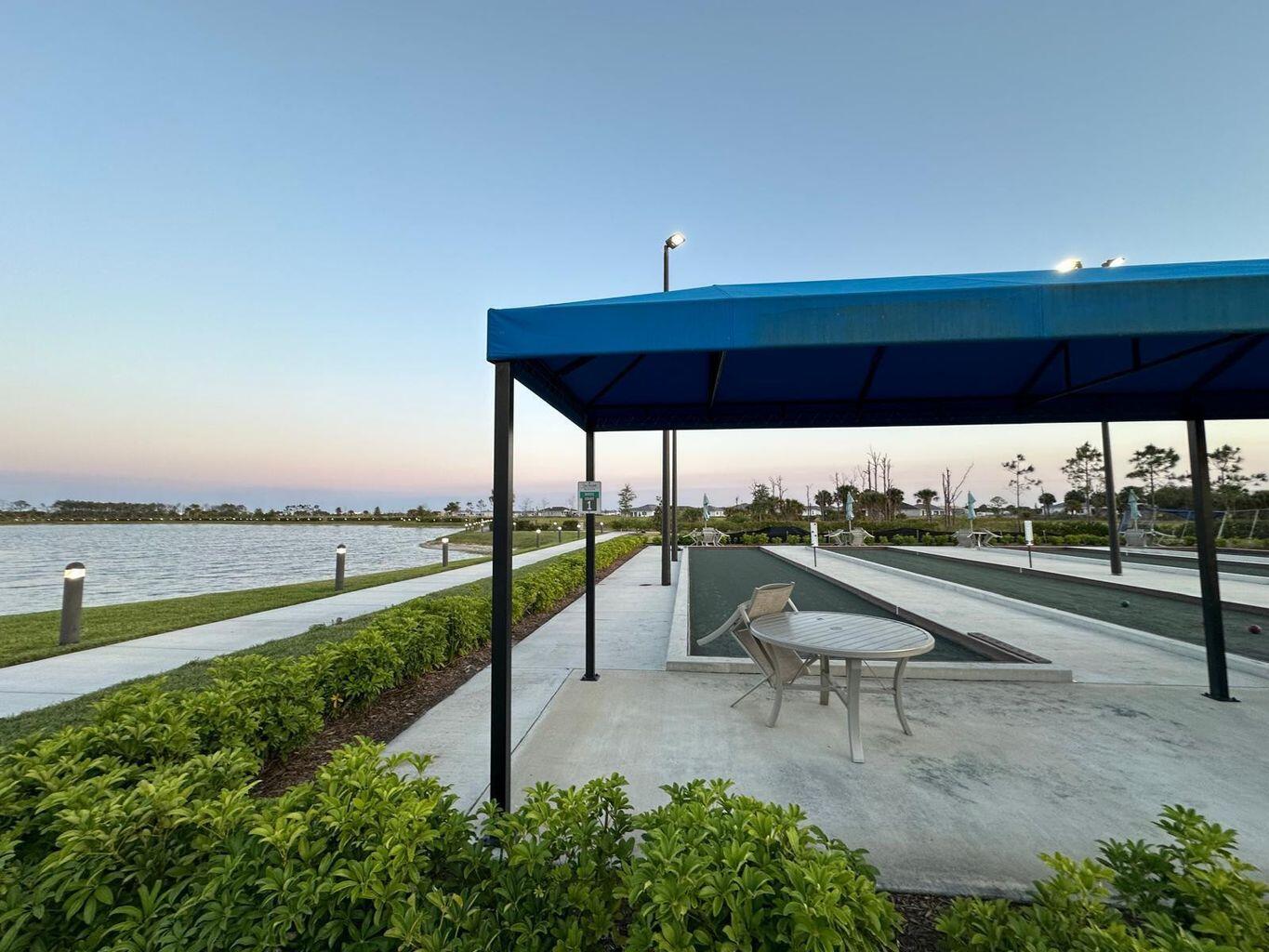 13897 Southwest Gingerline Drive Port St. Lucie, FL 34987 - Photo 29 of 74 a swimming pool with outdoor seating and garden
