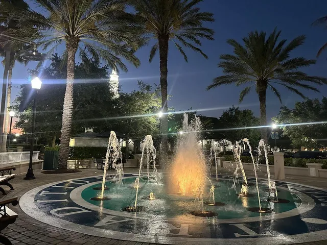 a kitchen with stainless steel appliances granite countertop a sink a stove a refrigerator cabinets and chairs