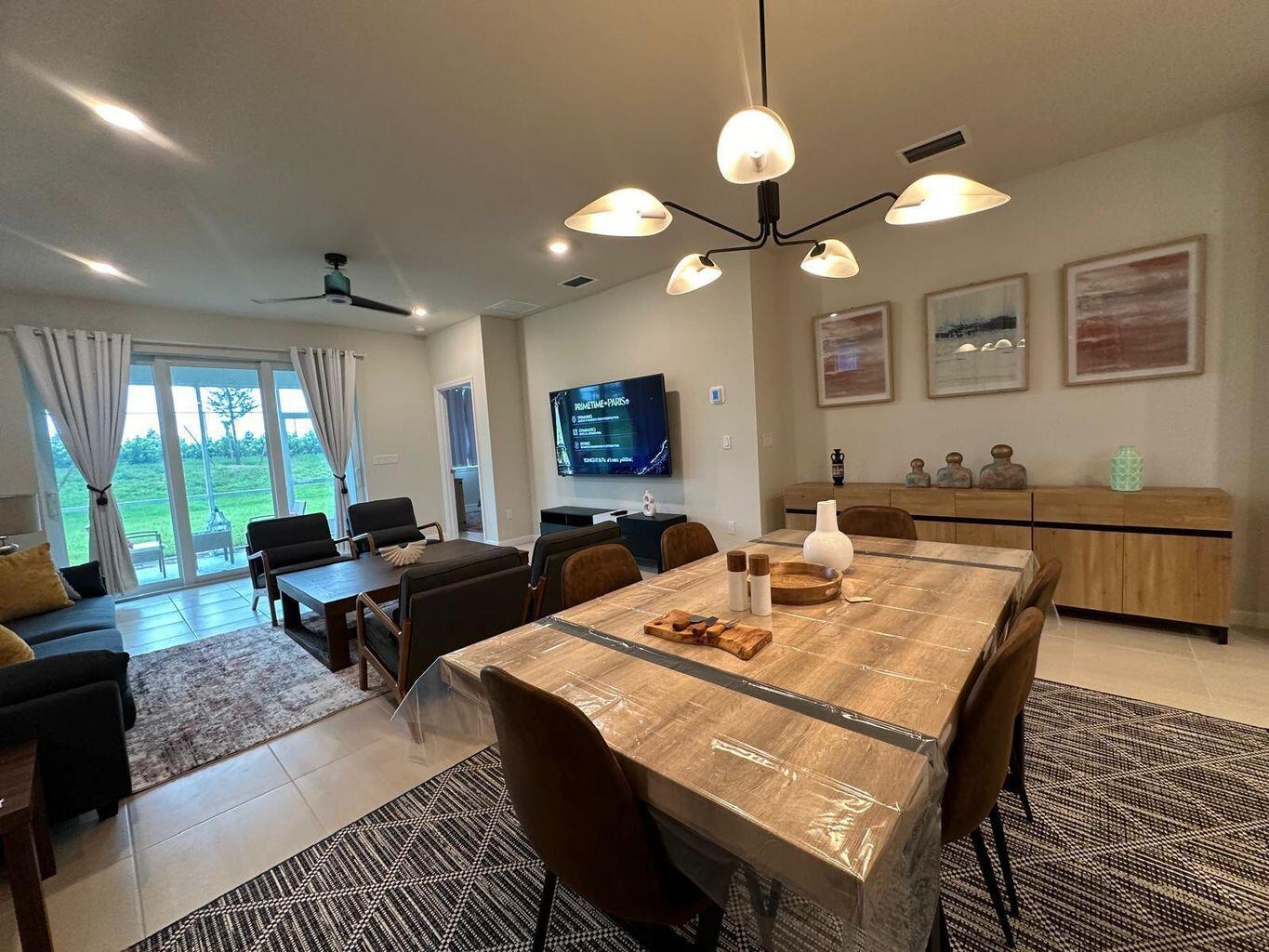 13897 Southwest Gingerline Drive Port St. Lucie, FL 34987 - Photo 35 of 74 a living room with furniture a chandelier and a flat screen tv