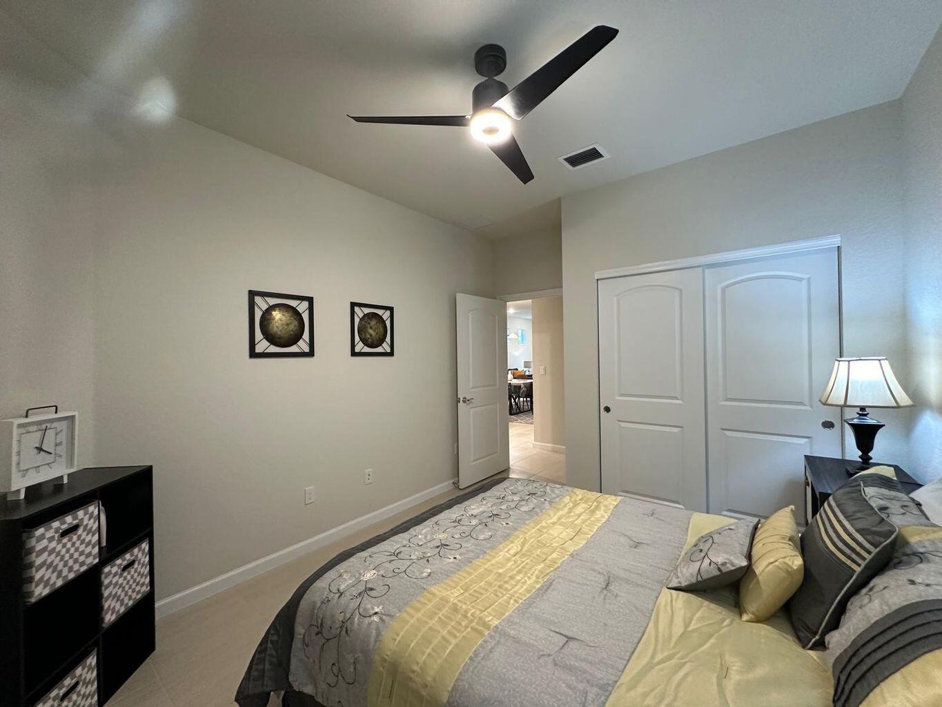 13897 Southwest Gingerline Drive Port St. Lucie, FL 34987 - Photo 38 of 74 a bedroom with a bed and a lamp