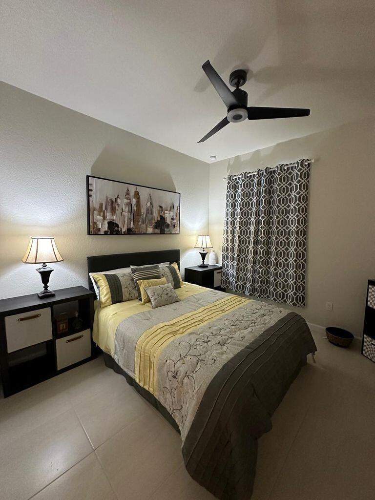 13897 Southwest Gingerline Drive Port St. Lucie, FL 34987 - Photo 40 of 74 a bedroom with a large bed and a chandelier
