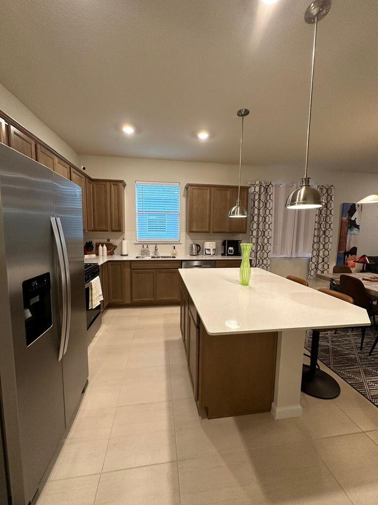 13897 Southwest Gingerline Drive Port St. Lucie, FL 34987 - Photo 46 of 74 a kitchen with stainless steel appliances a sink a counter top space cabinets and stainless steel appliances