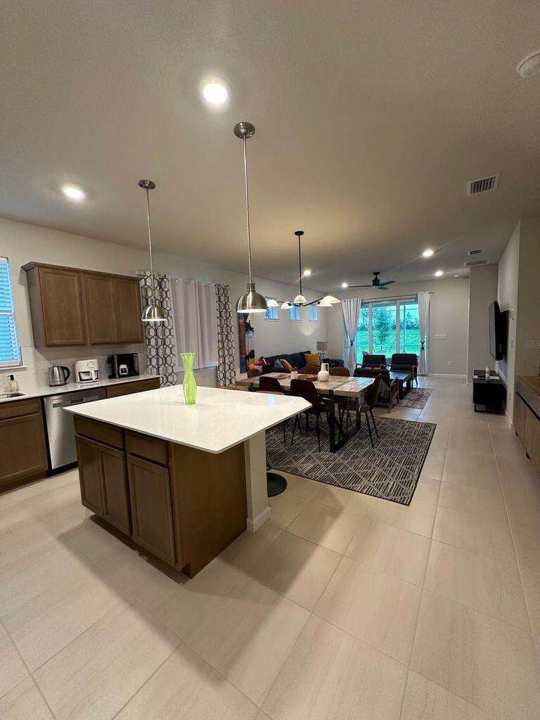 13897 Southwest Gingerline Drive Port St. Lucie, FL 34987 - Photo 47 of 74 a large kitchen with a large counter top a sink a stove a refrigerator and a cabinets