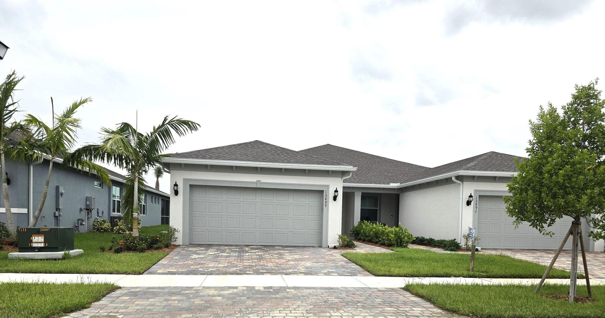 13897 Southwest Gingerline Drive Port St. Lucie, FL 34987 - Photo 7 of 74 a front view of a house with a garden and yard