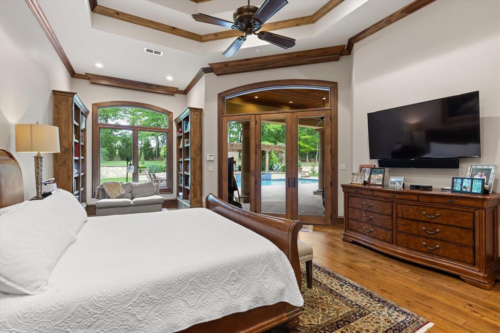 3705 Champions Ridge Lane Longview, TX 75605 - Photo 18 of 40 a bedroom with a bed and a flat tv screen on dresser