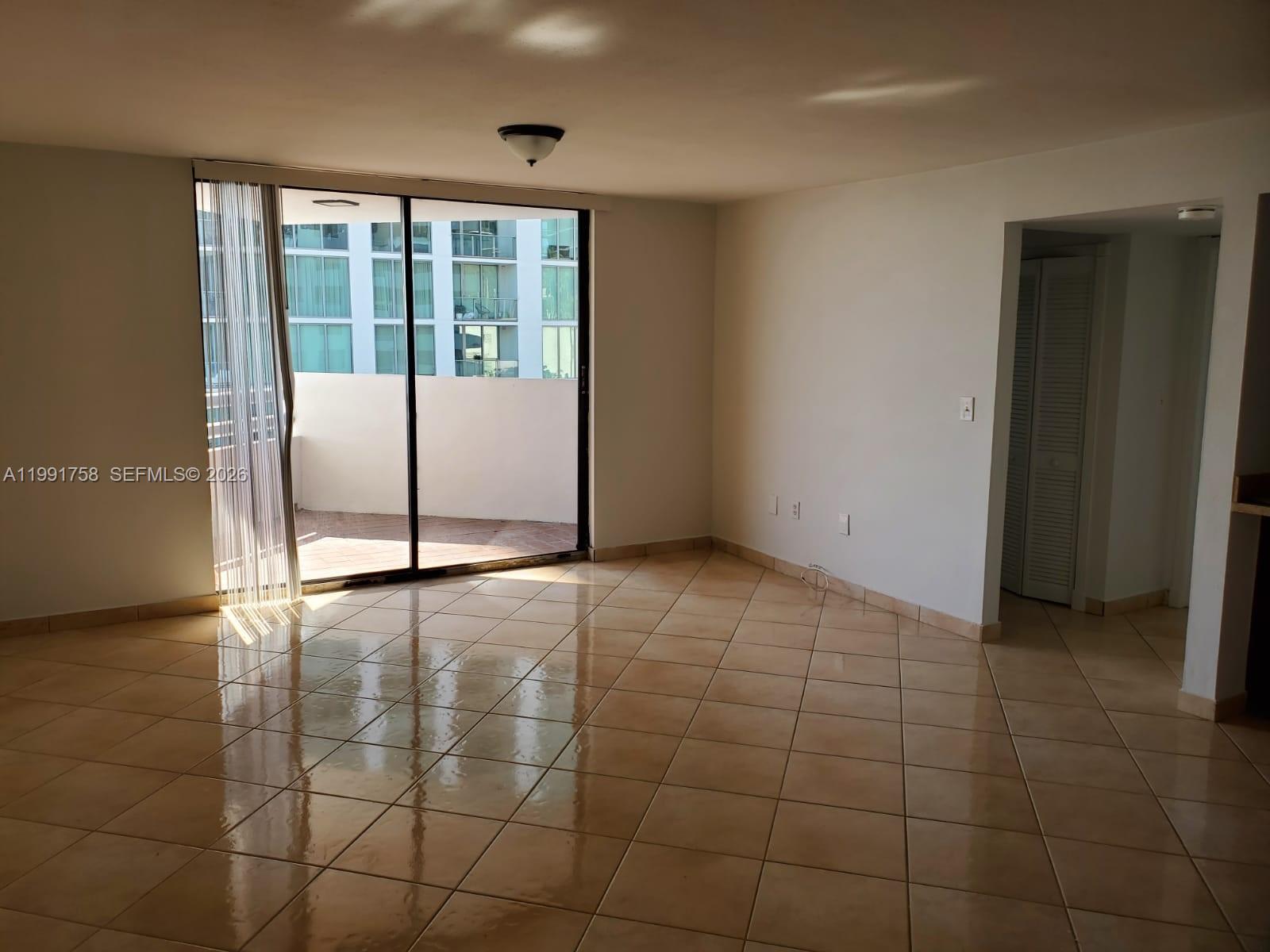 555 Northeast 30th Street, Unit 502 Miami, FL 33137 - Photo 5 of 19 a view of a livingroom with an empty space and a window