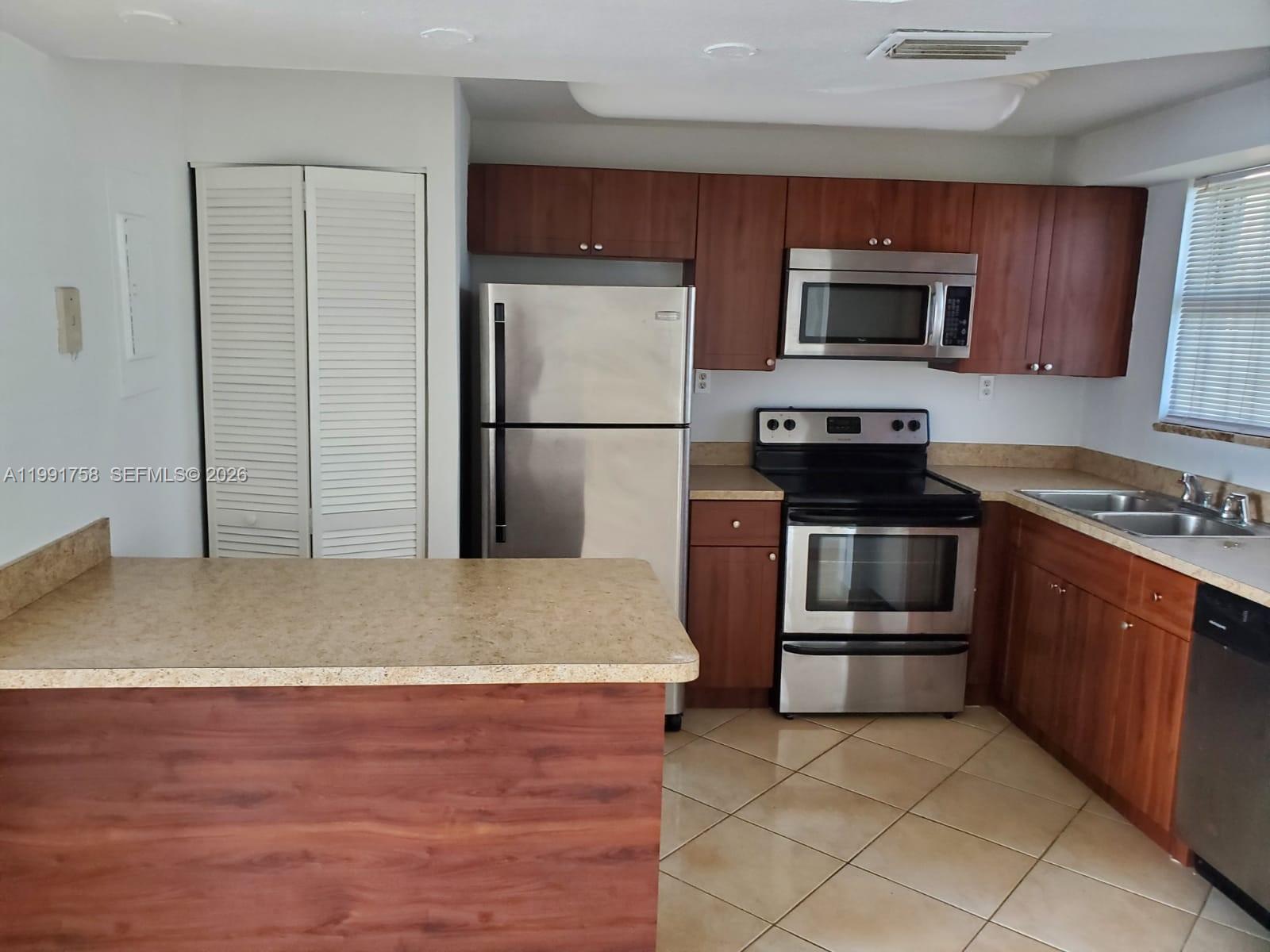 555 Northeast 30th Street, Unit 502 Miami, FL 33137 - Photo 6 of 19 a kitchen with stainless steel appliances granite countertop a stove a microwave and a refrigerator