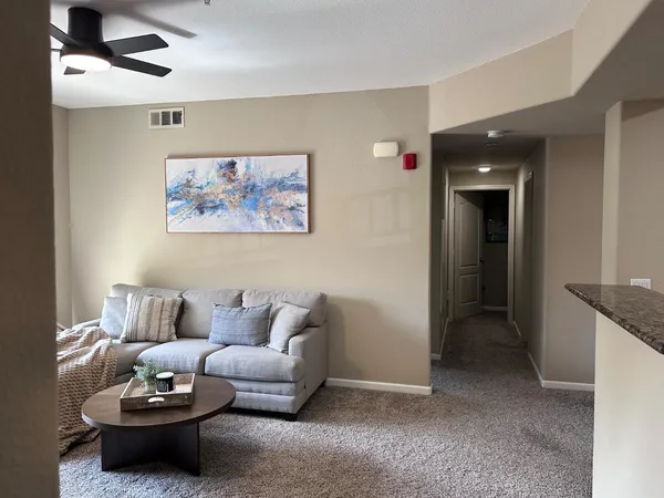 a living room with furniture and a ceiling fan