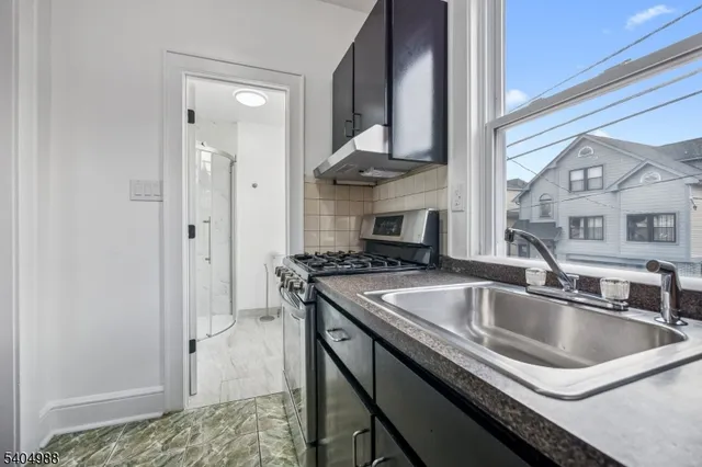 a kitchen with stainless steel appliances granite countertop a sink and a refrigerator