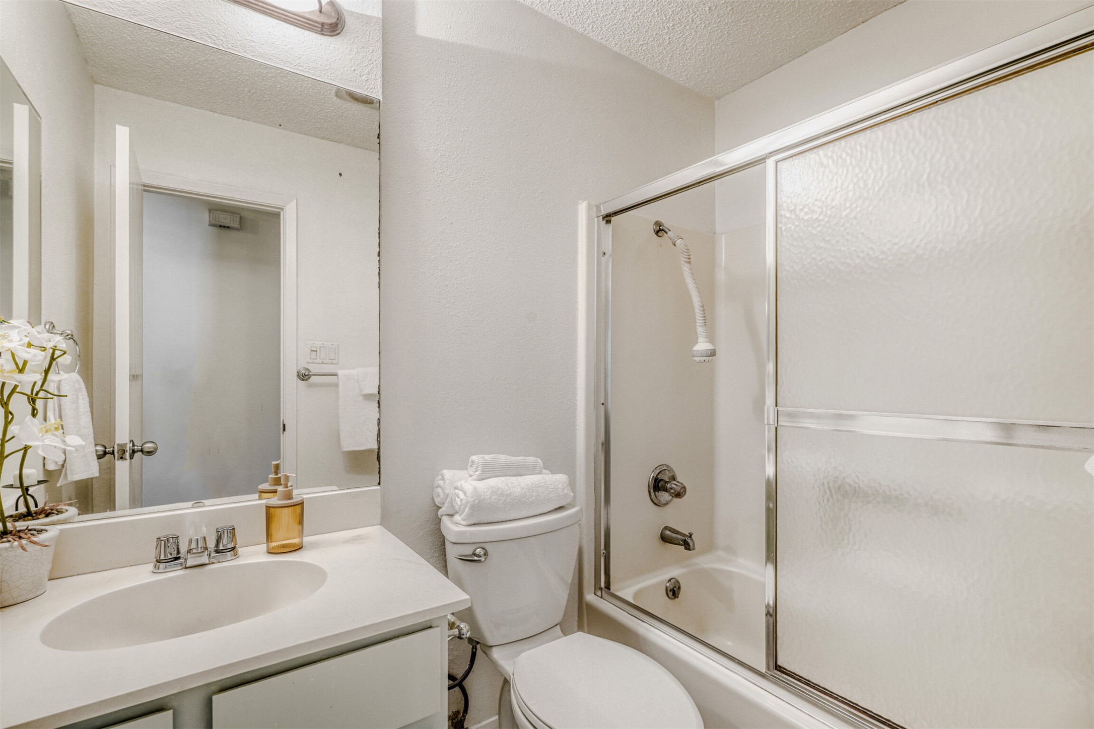 6701 Stage Coach Trail Austin, TX 78745 - Photo 17 of 23 Full bath with enclosed tub / shower combo, vanity, and a textured ceiling