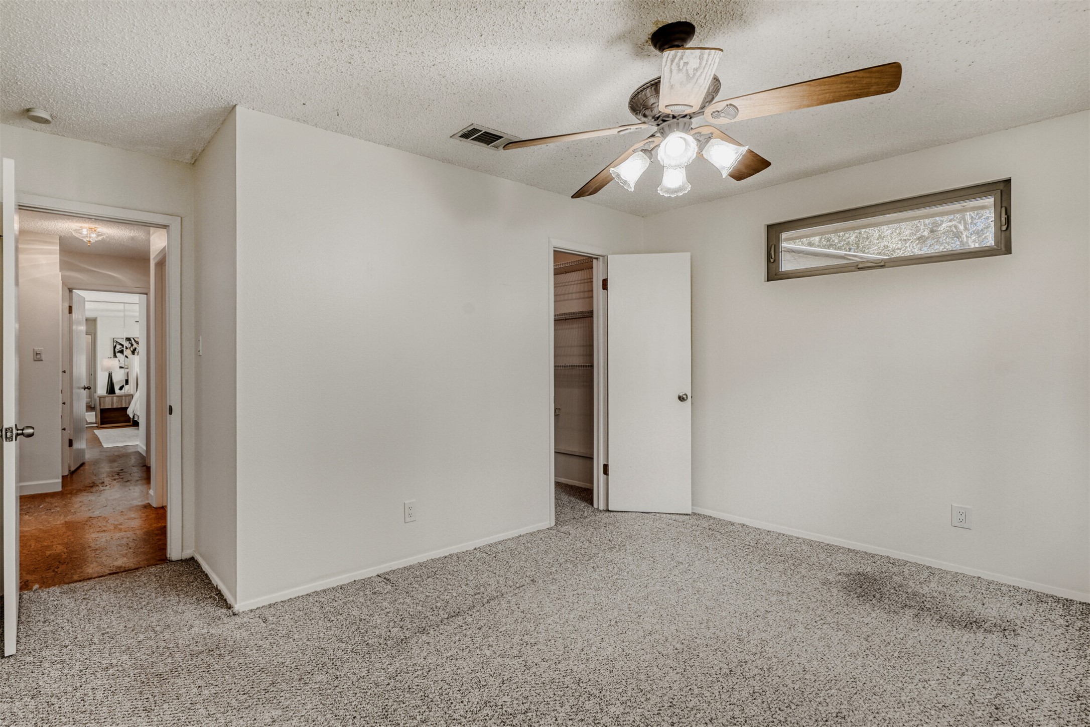 6701 Stage Coach Trail Austin, TX 78745 - Photo 19 of 23 Unfurnished bedroom featuring carpet floors, a textured ceiling, and a ceiling fan