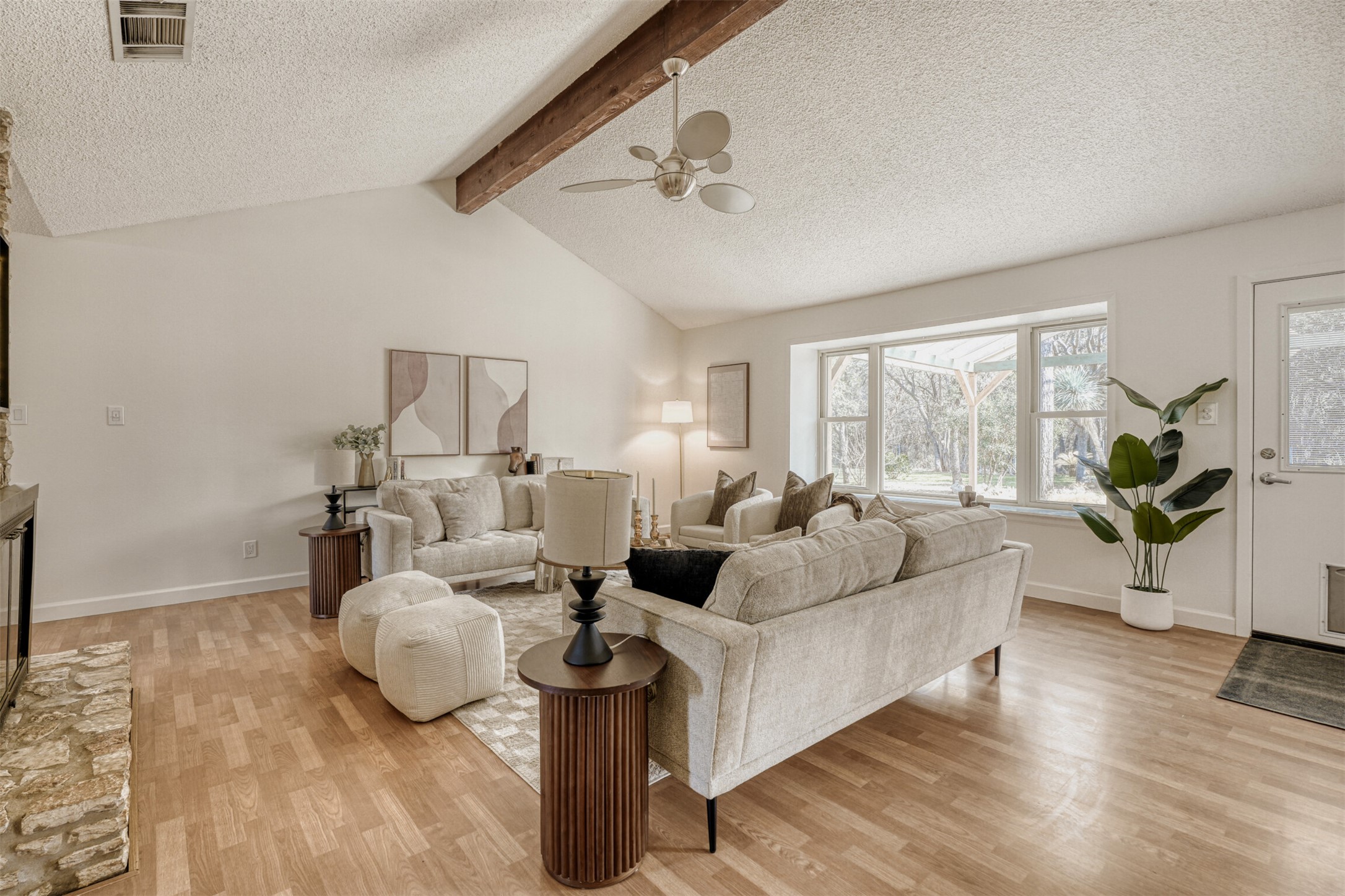 6701 Stage Coach Trail Austin, TX 78745 - Photo 4 of 23 Living area featuring a textured ceiling, a fireplace, light wood-style flooring, beam ceiling, and ceiling fan