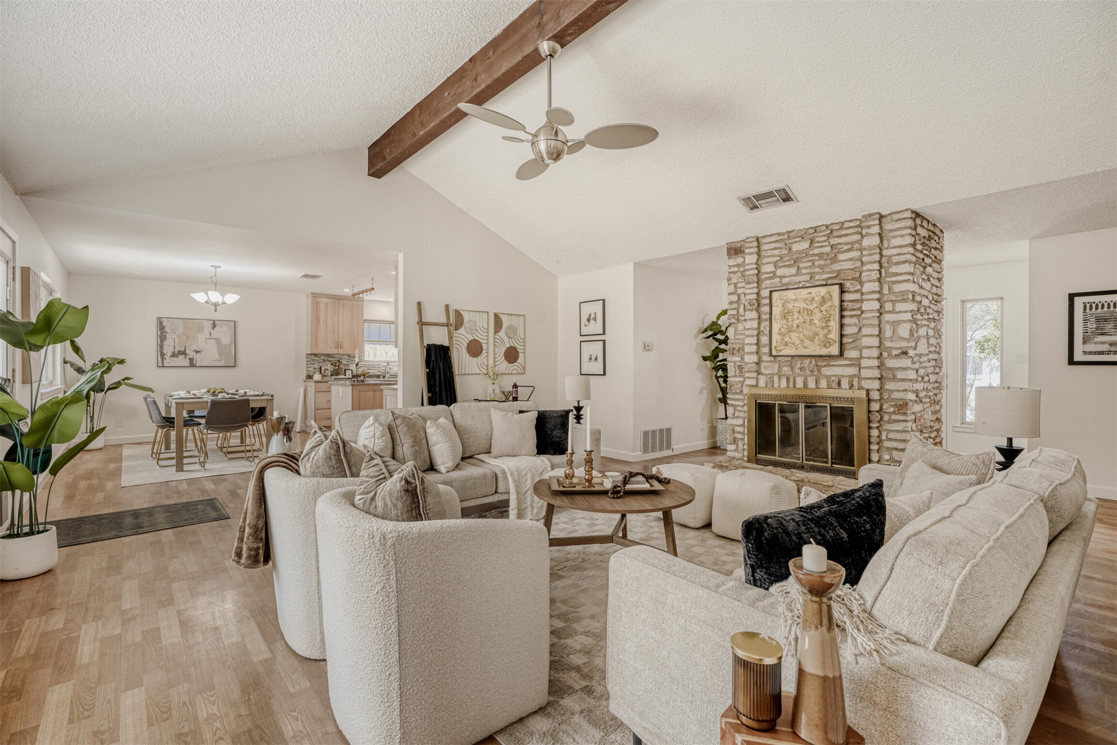6701 Stage Coach Trail Austin, TX 78745 - Photo 5 of 23 Living area with wood finished floors, a ceiling fan, a textured ceiling, a stone fireplace, and suspended lighting