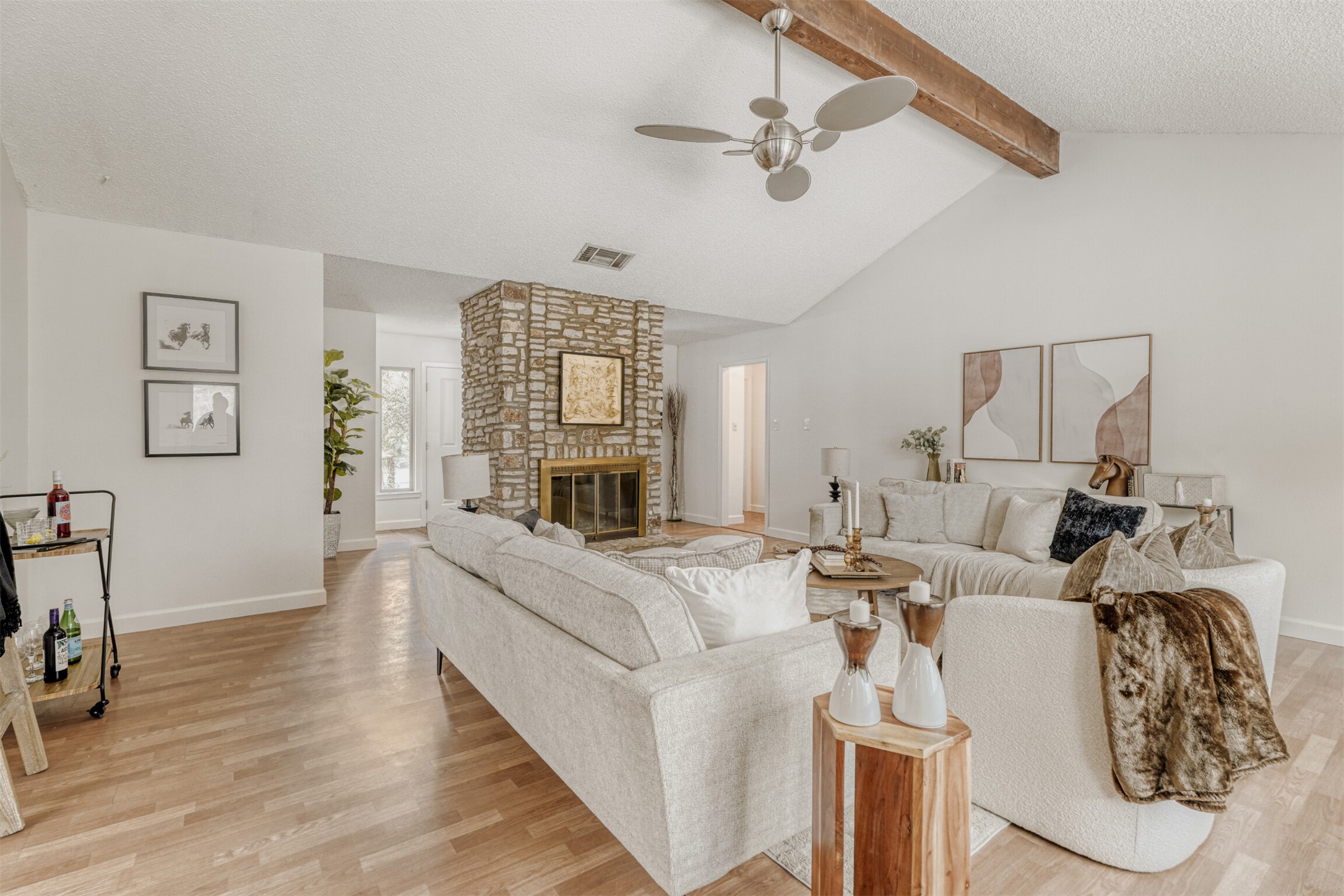 6701 Stage Coach Trail Austin, TX 78745 - Photo 6 of 23 Living room featuring ceiling fan, light wood finished floors, a textured ceiling, and a large fireplace