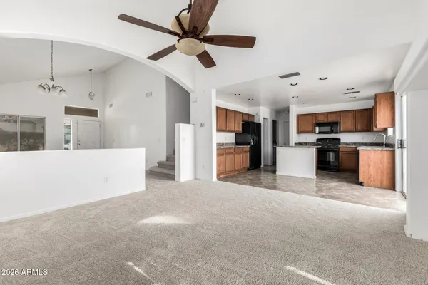 a kitchen with stainless steel appliances granite countertop a refrigerator a sink dishwasher a stove top oven a kitchen island and chairs with wooden floor