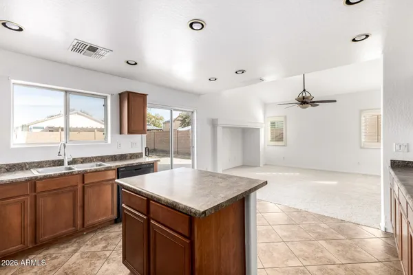 a kitchen with stainless steel appliances kitchen island granite countertop a refrigerator and stove