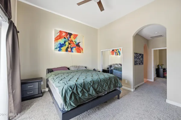 a bedroom with a bed and a painting on the wall