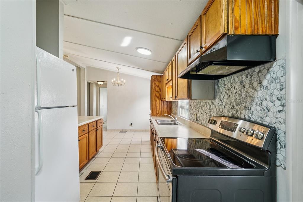4708 Gallagher Road Plant City, FL 33565 - Photo 43 of 62 a kitchen with stainless steel appliances granite countertop a stove and a refrigerator