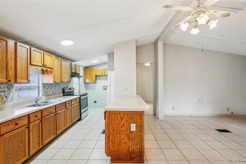 4708 Gallagher Road Plant City, FL 33565 - Photo 53 of 62 a large kitchen with kitchen island granite countertop a sink window and cabinets