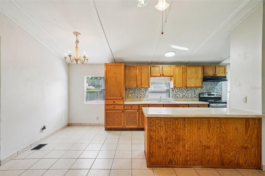 4708 Gallagher Road Plant City, FL 33565 - Photo 55 of 62 a large kitchen with kitchen island granite countertop a stove a sink and a refrigerator