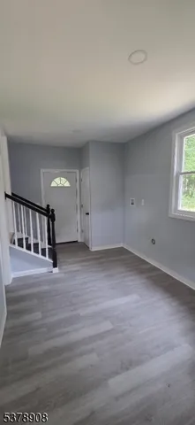 a view of a kitchen with kitchen island a sink wooden floor and a refrigerator