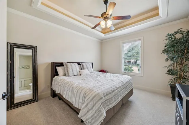 a bedroom with a large bed and a chandelier