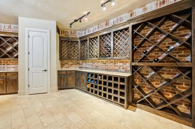 a spacious bedroom with a bed a chandelier and a flat screen television