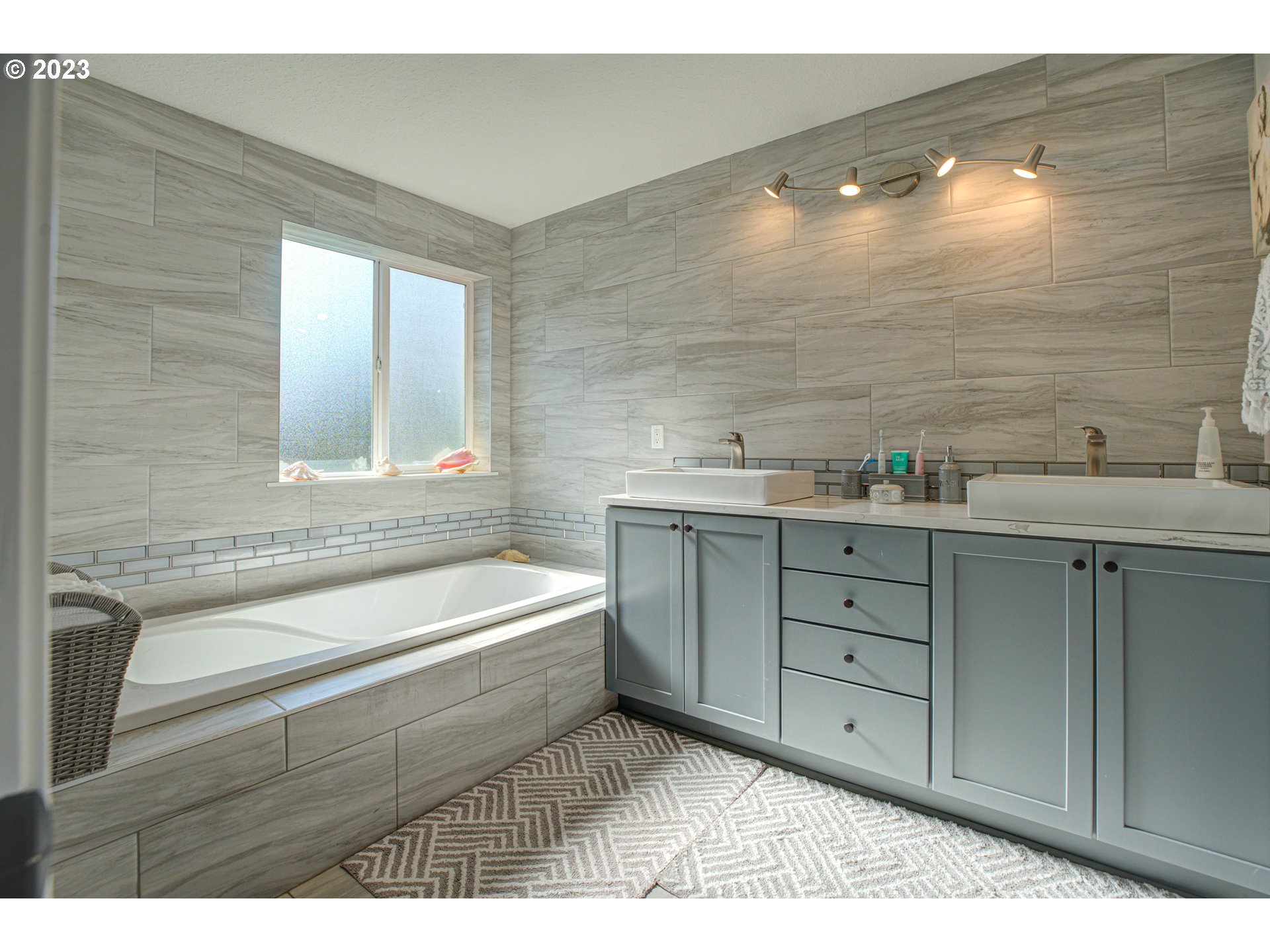 6055 Southeast 28th Street Gresham, OR 97080 - Photo 39 of 48 a bathroom with a sink a large mirror and a bathtub