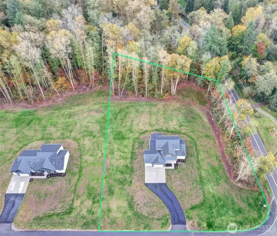 an aerial view of residential house with outdoor space and trees all around