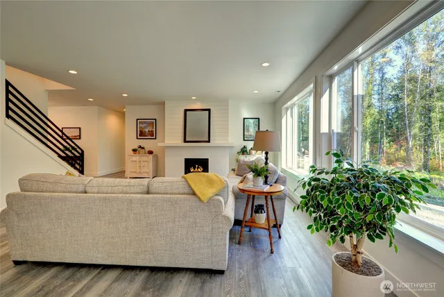 a living room with furniture potted plant and a large window