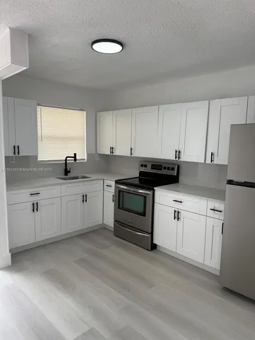 a kitchen with granite countertop white cabinets and white appliances