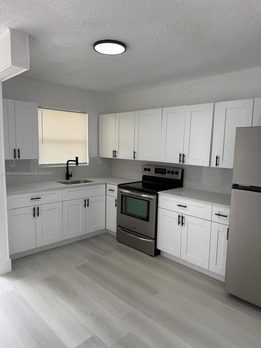 a kitchen with granite countertop white cabinets and white appliances