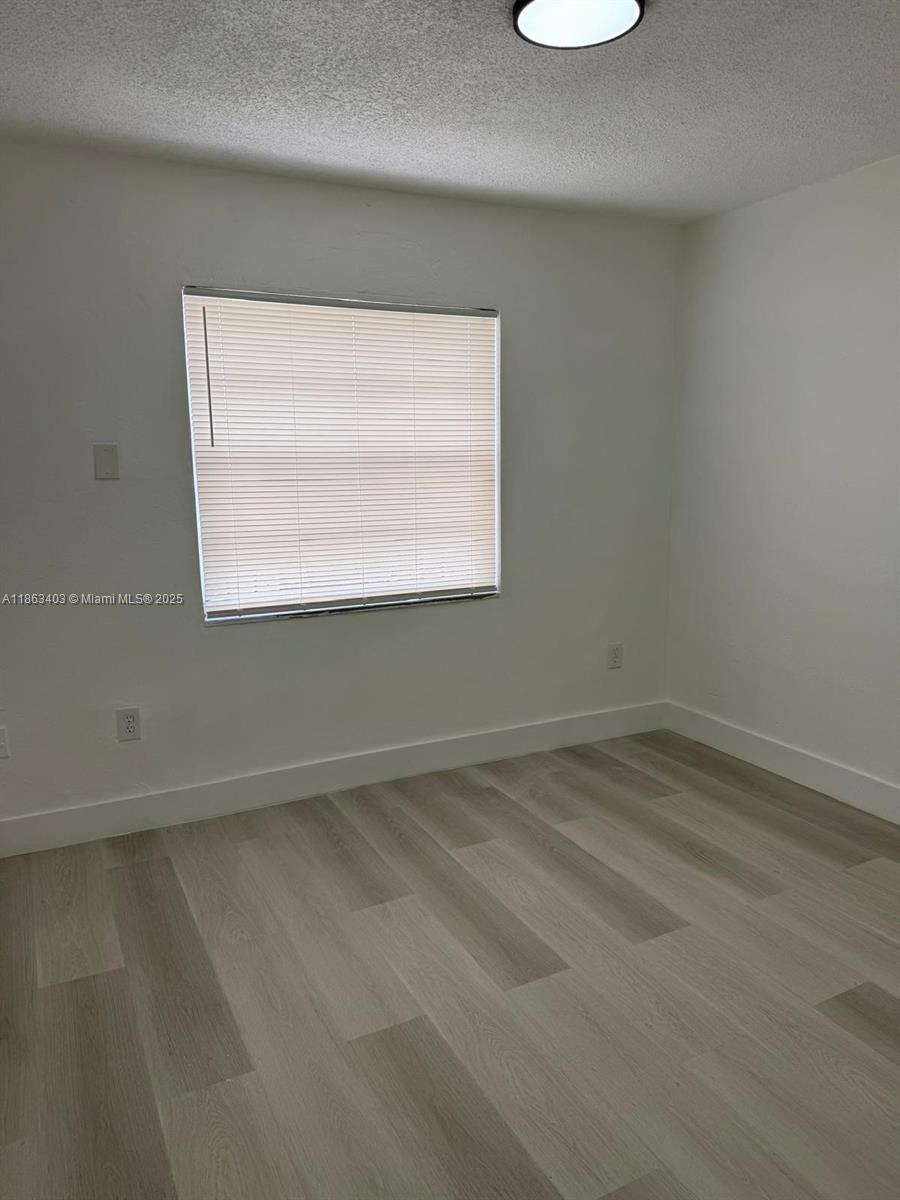 1000 West 28th Street, Unit 16 Hialeah, FL 33010 - Photo 8 of 13 an empty room with a window
