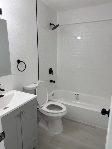 a bathroom with a toilet sink a mirror and shower