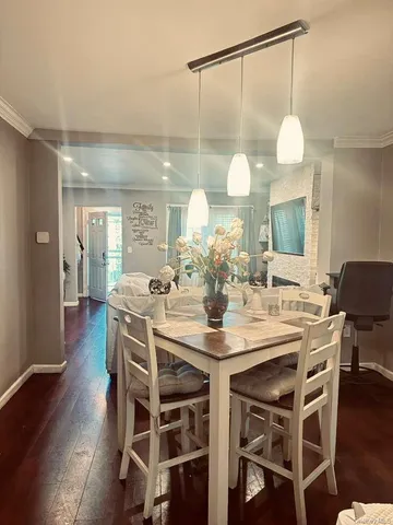 a dining room with wooden floor a glass table and chairs