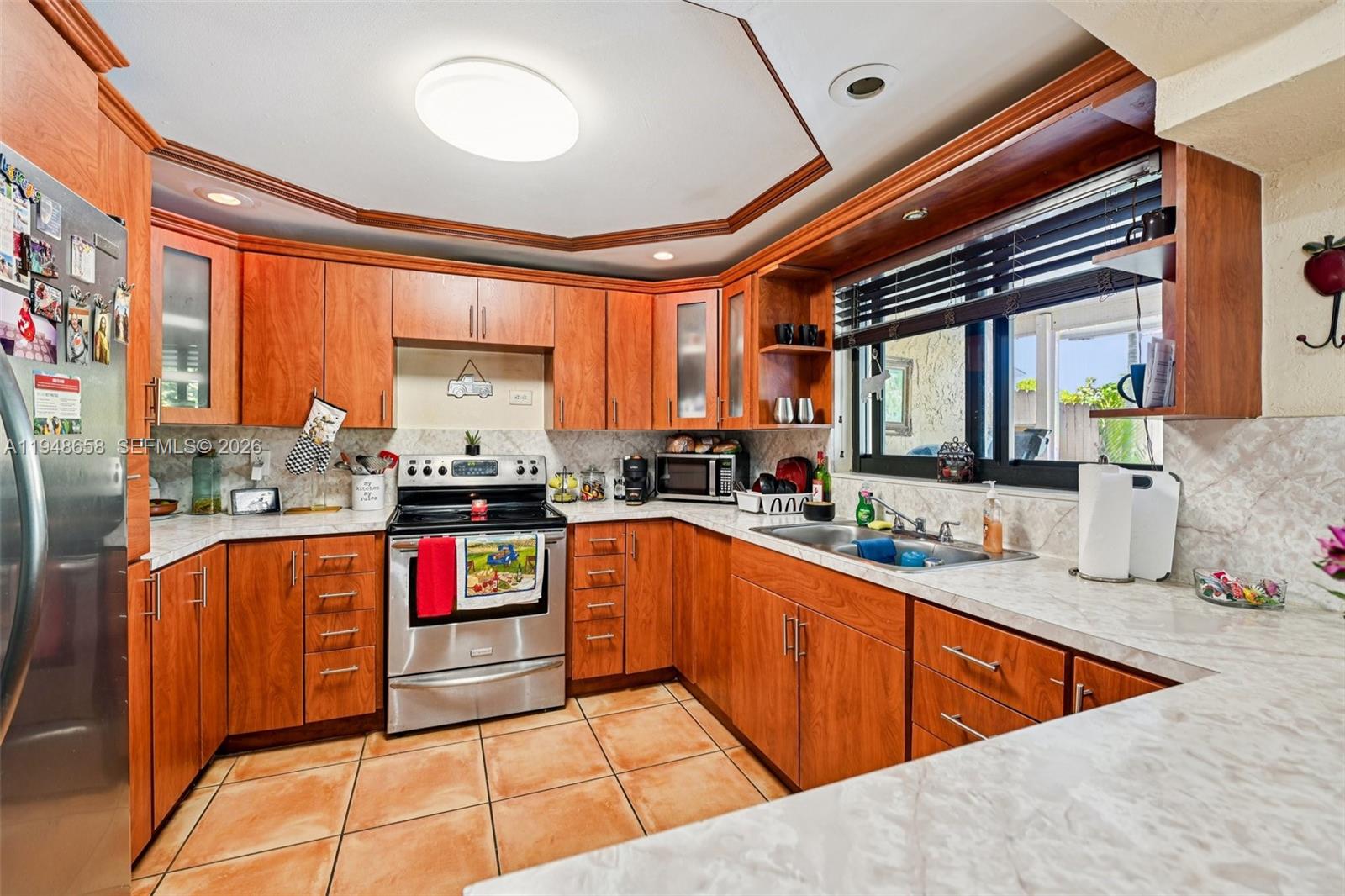 10365 Southwest 11th Terrace, Unit 49B Miami, FL 33174 - Photo 11 of 36 a kitchen with stainless steel appliances granite countertop sink stove and cabinets