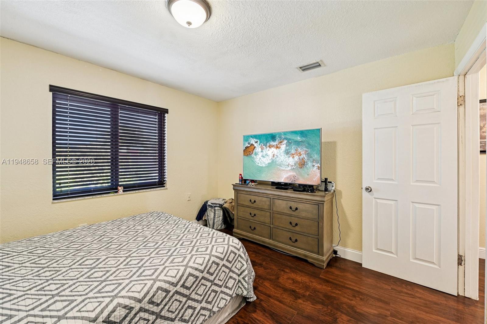 10365 Southwest 11th Terrace, Unit 49B Miami, FL 33174 - Photo 20 of 36 a bedroom with a bed and a flat tv screen on dresser