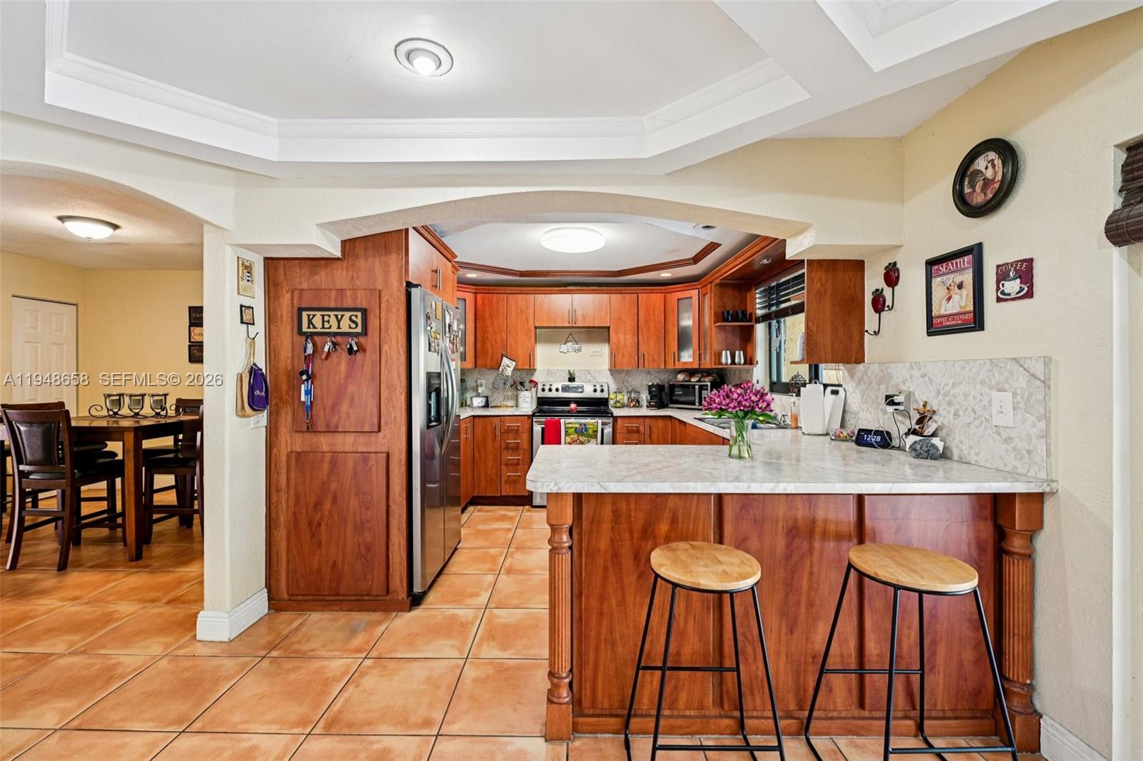 10365 Southwest 11th Terrace, Unit 49B Miami, FL 33174 - Photo 10 of 36 a kitchen with stainless steel appliances granite countertop a table chairs and a refrigerator