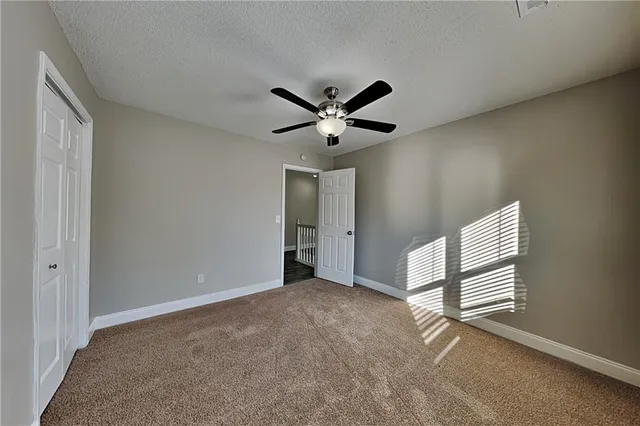a view of an empty room with a ceiling fan