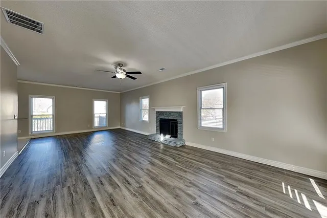 a view of an empty room with window and wooden floor