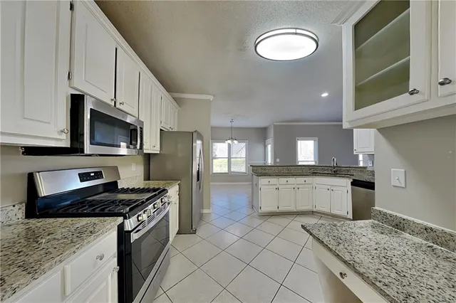 a kitchen with stainless steel appliances granite countertop a stove sink and cabinets