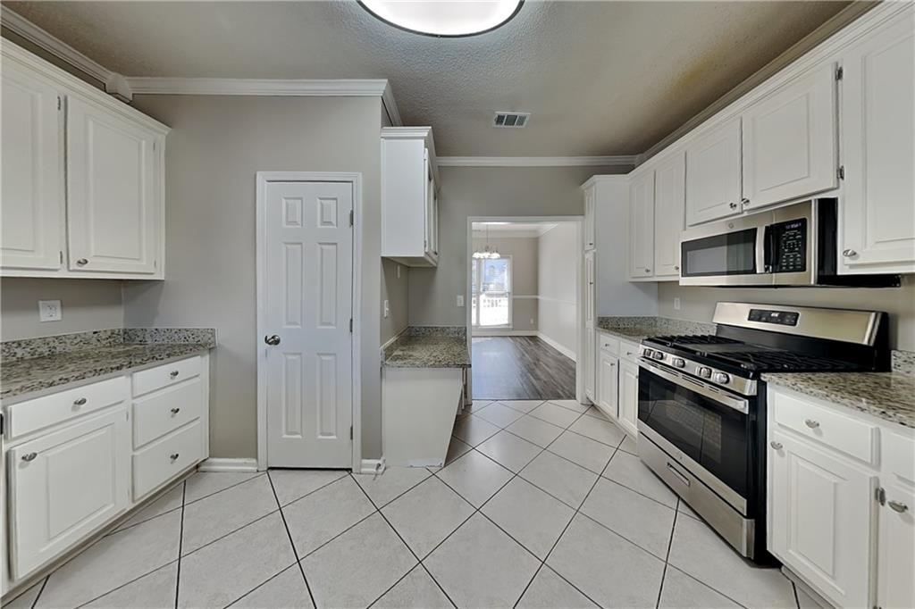 5305 Rutland Court Powder Springs, GA 30127 - Photo 5 of 22 a kitchen with stainless steel appliances granite countertop a stove a sink and a refrigerator