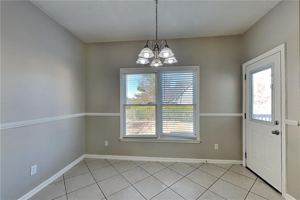5305 Rutland Court Powder Springs, GA 30127 - Photo 6 of 22 an empty room with windows and chandelier