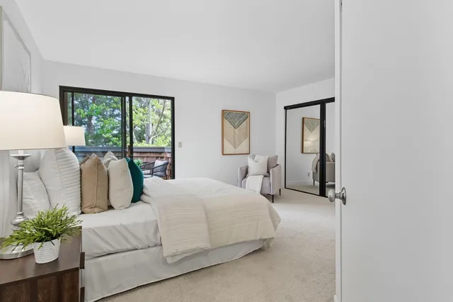 a bedroom with a large bed and a potted plant