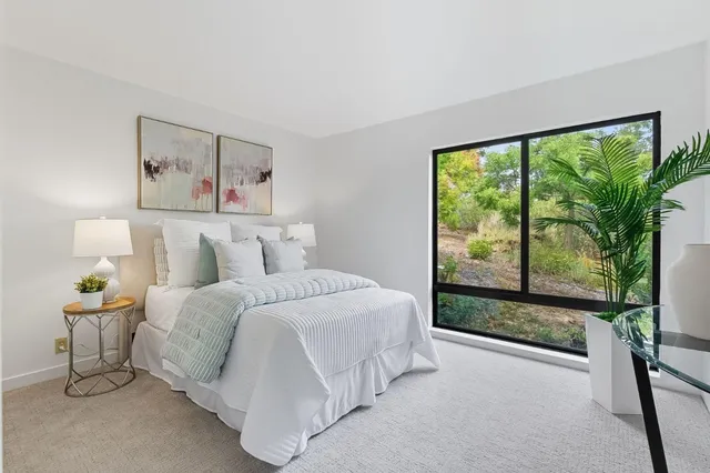 a spacious bedroom with a bed and a large window