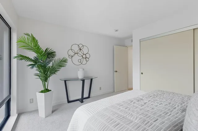 a bedroom with a bed and a potted plant