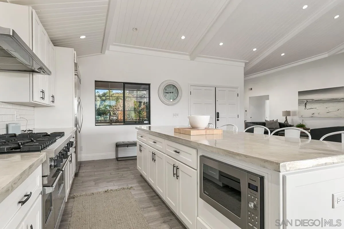 970 Saxony Road Encinitas, CA 92024 - Photo 11 of 39 a kitchen with a sink stove and cabinets
