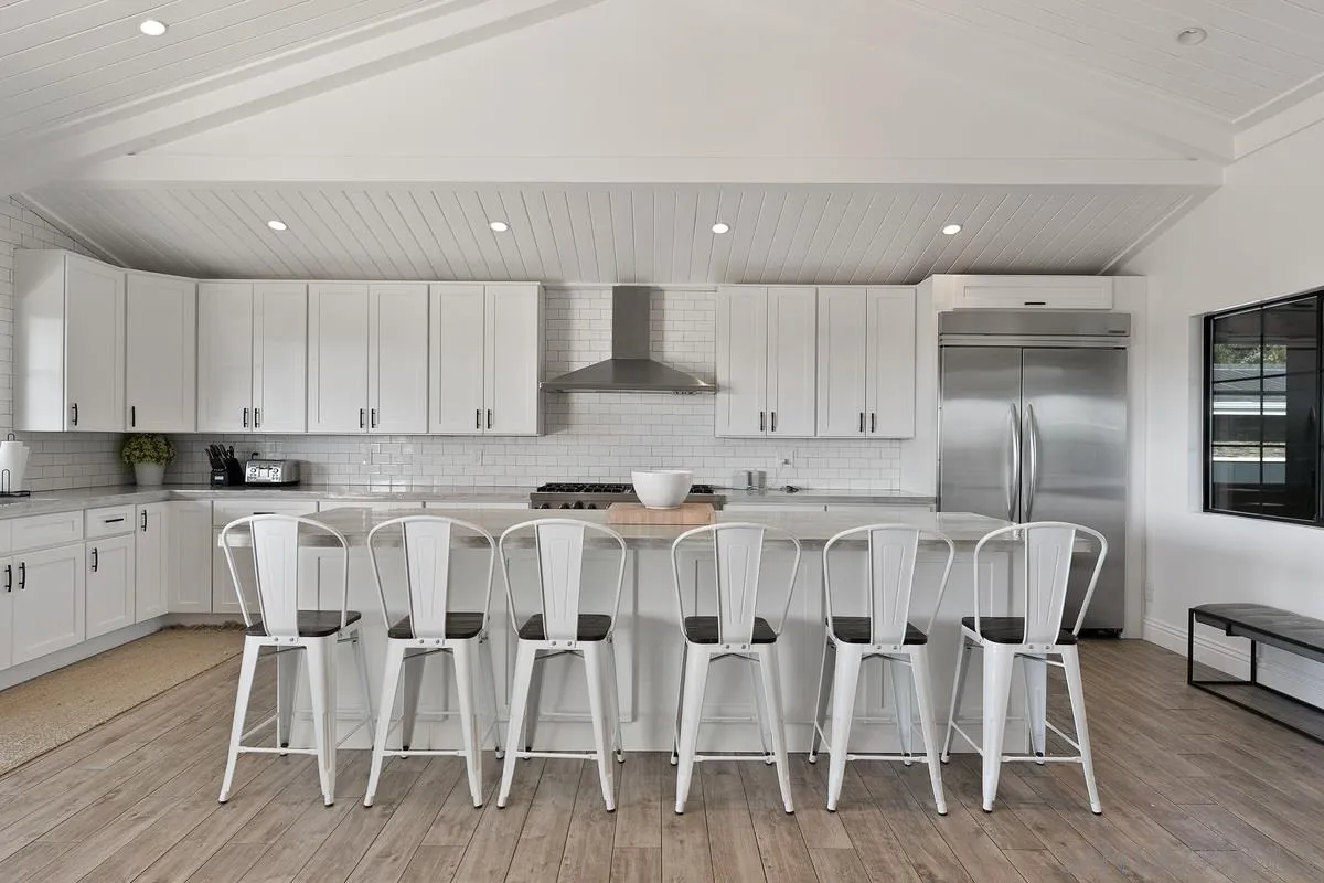 970 Saxony Road Encinitas, CA 92024 - Photo 12 of 39 a kitchen with stainless steel appliances cabinets wooden floor and chairs