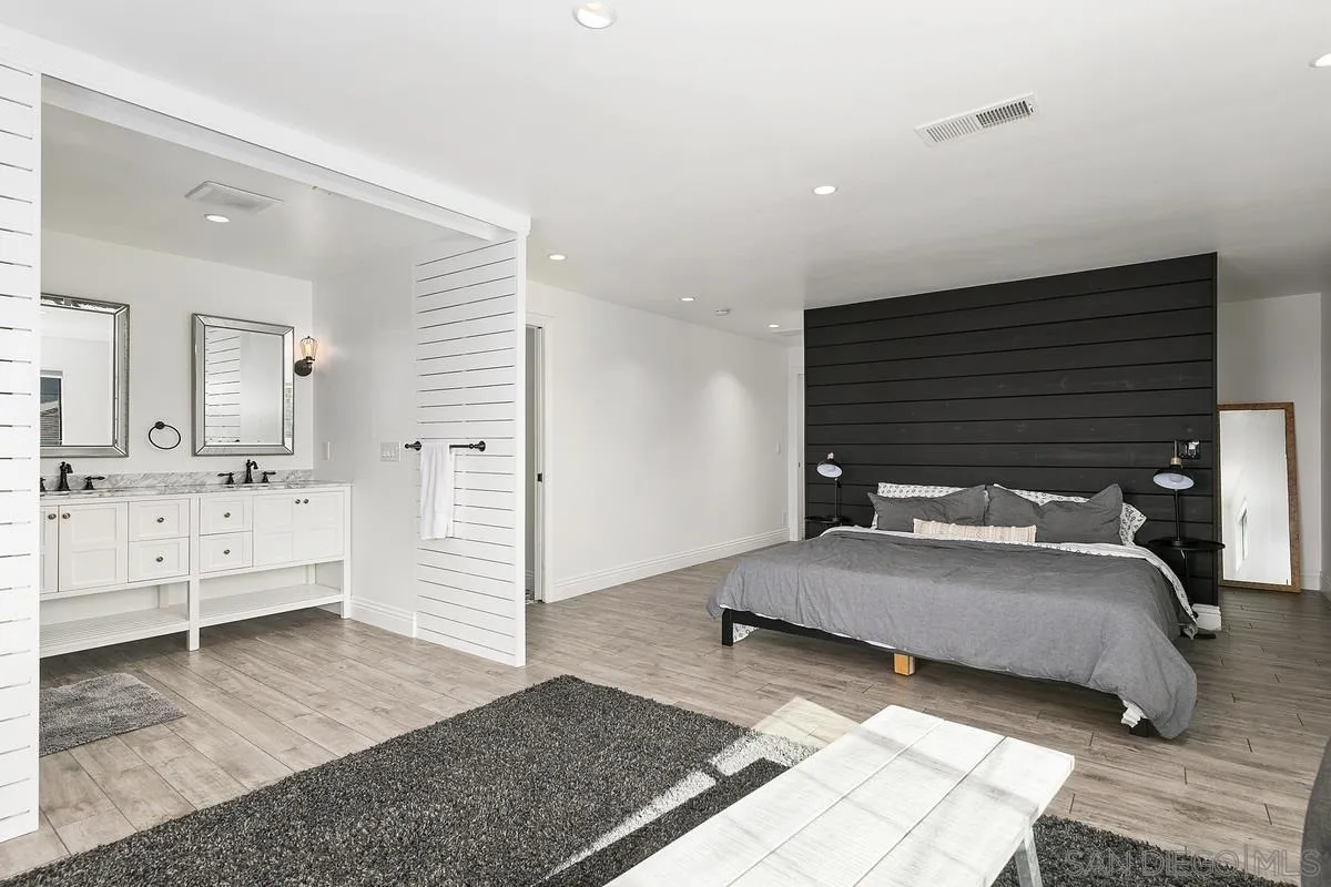 970 Saxony Road Encinitas, CA 92024 - Photo 14 of 39 a bedroom with a bed and a large mirror